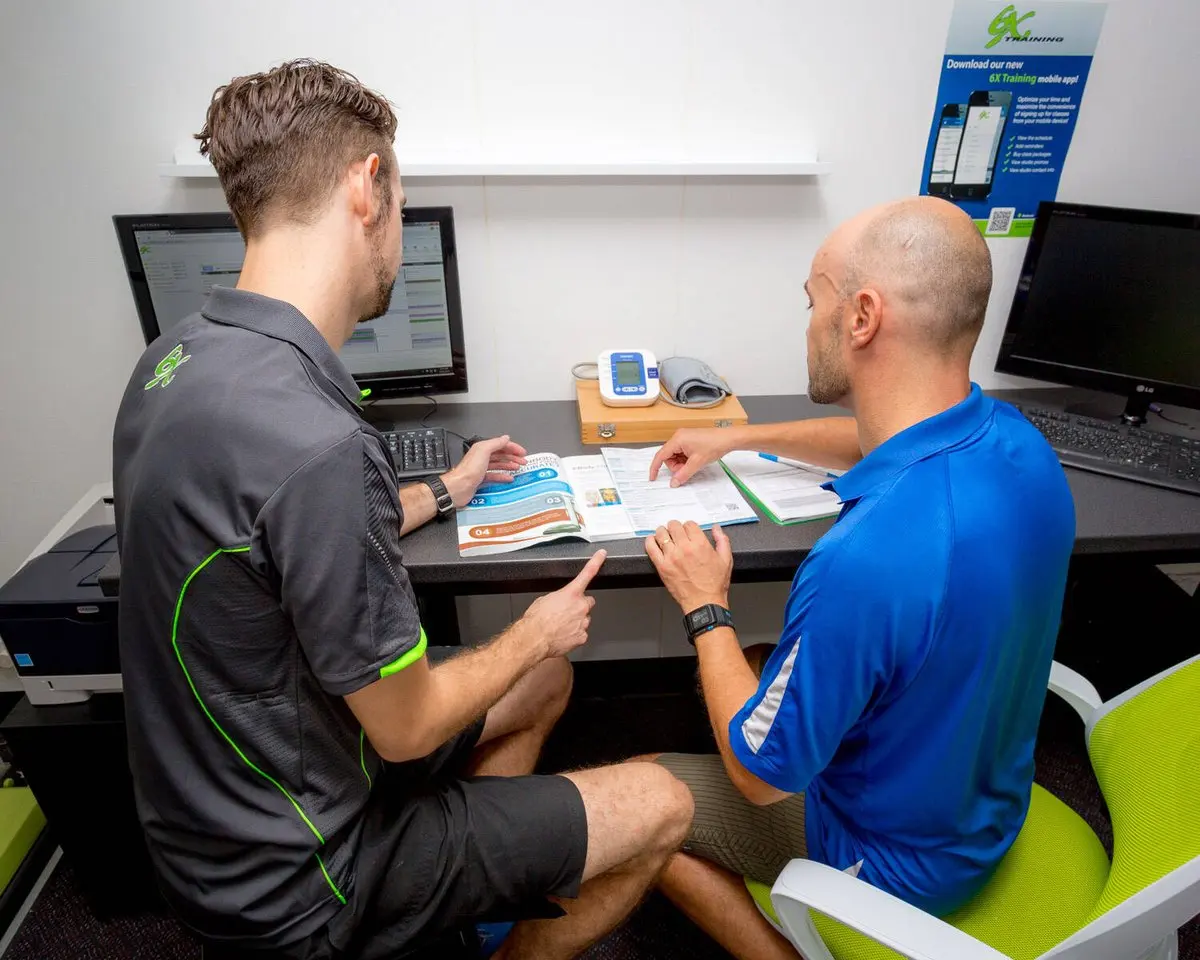 6X coach reviewing a personalised training plan with a member